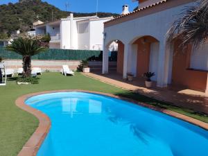 a swimming pool in the yard of a house at Villa Costa. in Tossa de Mar