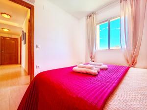 a bedroom with a red bed with towels on it at Albatros Playa 2 - 5810 in Mar de Cristal +37 photos