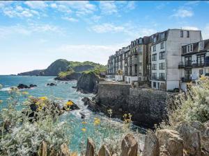 un edificio vicino all'oceano con fiori di White Horses - Seaviews a Ilfracombe