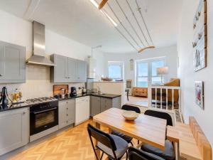 una cucina con un tavolo di legno e una sala da pranzo di White Horses - Seaviews a Ilfracombe