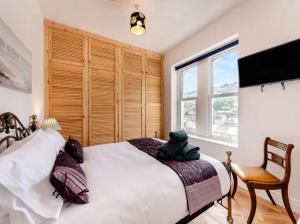 una camera da letto con un grande letto bianco e una finestra di White Horses - Seaviews a Ilfracombe