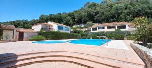 a swimming pool in a yard with houses at Coconhut Studio - Terrace - Pool in Villeneuve-Loubet