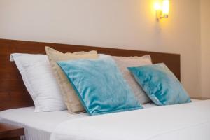 a bed with blue pillows on top of it at Hotel Odissey Jaz in Budva