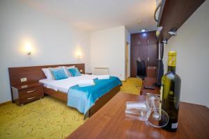 a bedroom with a bed and a bottle of wine at Hotel Odissey Jaz in Budva