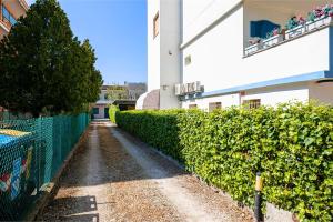 a walkway in front of a building with a hedge at SUMMER - Casa a due passi dal mare con Free Parking e Wi-Fi in Cesenatico