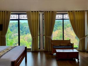 ein Schlafzimmer mit einem Bett und einem Stuhl sowie großen Fenstern in der Unterkunft Pondok Senaru Cottages in Senaru + 22 Fotos