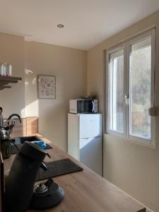 a kitchen with a counter top and a refrigerator at Douce Escale en Plein Centre - Avec Parking privé in Boulogne-sur-Mer