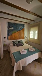 a bedroom with a large bed with two towels on it at La Tina, la pariera in Santiago de la Espada