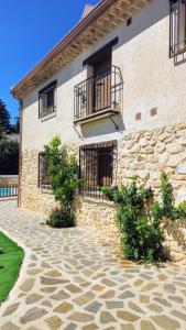 a stone building with a balcony and a patio at La Tina, la pariera in Santiago de la Espada