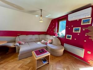 a living room with a white couch and red walls at Apartment Crystal Rose in Kranjska Gora