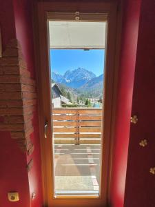 a door to a balcony with a view of a mountain at Apartment Crystal Rose in Kranjska Gora +32 photos