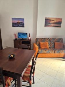 a living room with a table and a couch at Casa vacanze MARIA AMATO in Marsala