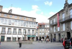 un grupo de personas caminando por una ciudad en Hostal Santo Grial, en Santiago de Compostela