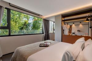 a hotel room with a bed and a large window at Cheens Hotel in Chengdu