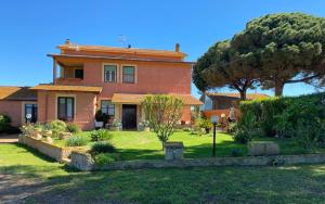 a large house with a tree in the yard at Casa Diana in Tarquinia