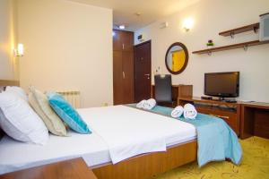 a bedroom with a large white bed with blue pillows at Hotel Odissey Jaz in Budva