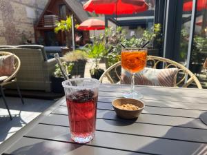 a table with two drinks and a bowl of snacks at Le Trophée Boutique Hôtel Spa- La Loggia Appart'hôtel in Deauville