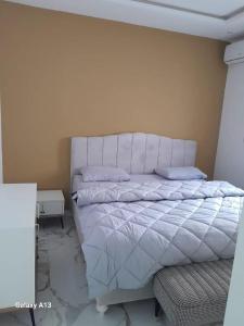 una camera con letto bianco e testiera bianca di Nkc guest a Nouakchott