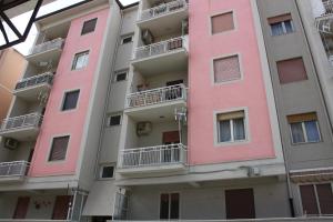 un edificio de apartamentos con pintura rosa. en Emma's House, en Agrigento