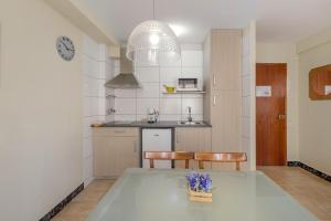 a kitchen with a table and two chairs and a sink at El Portal in Sant Llorenc de Morunys