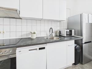 a white kitchen with a sink and a microwave at Loft & Living am Geiseltalsee in Braunsbedra