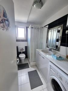 a white bathroom with a sink and a toilet at Apartment Perla in Dinjiška +20 photos