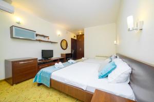 a hotel room with a bed and a television at Hotel Odissey Jaz in Budva