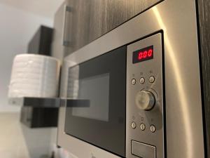 een magnetron met een rode klok erop bij KS Spacious Studio Apartment in Accra