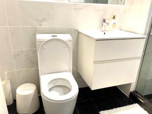 een witte badkamer met een toilet en een wastafel bij KS Spacious Studio Apartment in Accra +18 foto's