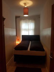 un letto in una camera da letto con finestra di Berlin Apartments Mitte a Berlino