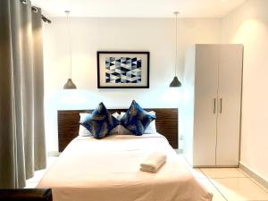 een slaapkamer met een groot bed met blauwe kussens bij KS Spacious Studio Apartment in Accra