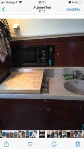 a kitchen counter with a cutting board in front of a microwave at Bateau au coeur d'Hendaye in Hendaye