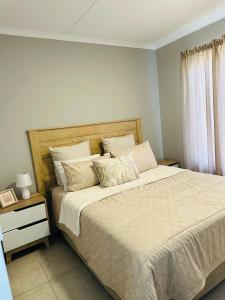 Un dormitorio con una cama grande y una ventana. en Homely Stay 4, en Kempton Park