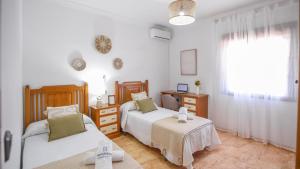 a bedroom with two beds and a desk and a window at Villa Paqui Villanueva de la Concepción by Ruralidays in Villanueva de la Concepción +26 photos