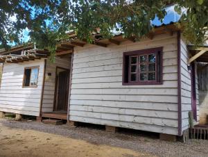 a small white house with a window on the side at Pousada Deck 950 - Cambará do Sul in Cambará