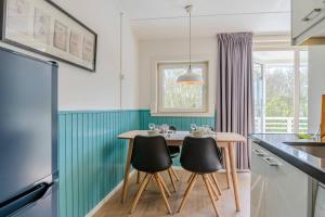 een keuken met een houten tafel en stoelen bij Hello Zeeland - Appartement Beatrixstraat 27 in Domburg