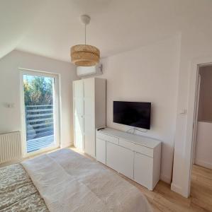 a living room with a tv and a white cabinet at Przystanek Osłonin- całoroczny dom na wynajem in Osłonin +24 photos