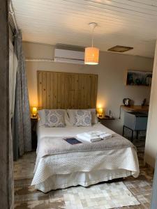 a bedroom with a large bed with a wooden headboard at Pousada Cape Town - Cambará do Sul in Cambara do Sul