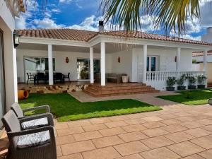 a home with a patio and a house at Villa Coral in Cala en Blanes