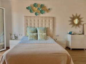 a bedroom with a large bed with pillows and a mirror at Villa Coral in Cala en Blanes +22 photos