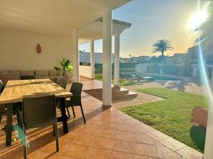 a dining room with a table and chairs on a patio at Villa Coral in Cala en Blanes