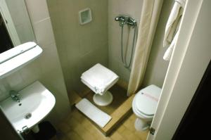 een kleine badkamer met een wastafel en een toilet bij Amalia in Thessaloniki