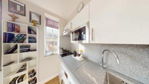 a kitchen with white cabinets and a sink at Chelsea Executive Cloisters 571 in London