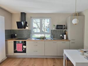 Una cocina con gabinetes blancos y un horno de estufa. en Charmante 3-Schlafzimmer Wohnung mit Garten, en Lörrach 27 fotos más