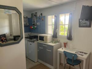 a small kitchen with a table and a microwave at Penn Ar Bed & Breakfast in Plozévet