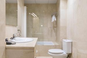 a bathroom with a white toilet and a sink at Plaza Mayor by Forever Rentals in Madrid +19 photos