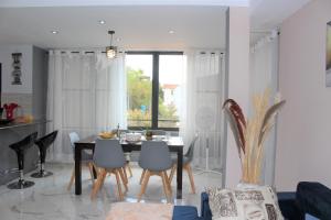 a dining room and living room with a table and chairs at Appartement BIKA à 5 mn de l'aéroport d'Ivato - navette privée gratuite in Talata-maty