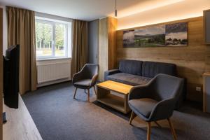 salon z kanapą i 2 krzesłami w obiekcie Sporthotel Olympia w mieście Stachy