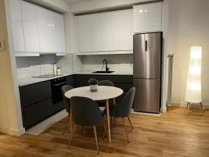 a kitchen with a table and chairs and a refrigerator at BW Eterna Apartment in Sajmište