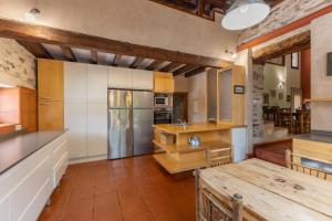 cocina grande con mesa y nevera en La Casona y Casitas de Tabladillo, en Santa María la Real de Nieva